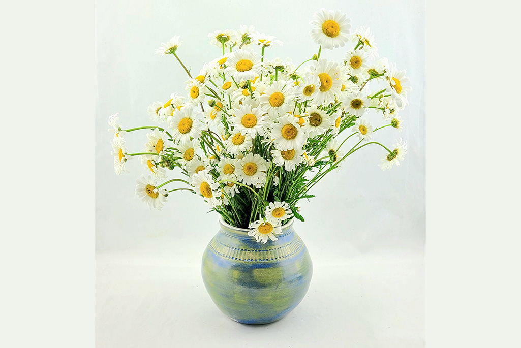 Bild på en vas med blommor i.