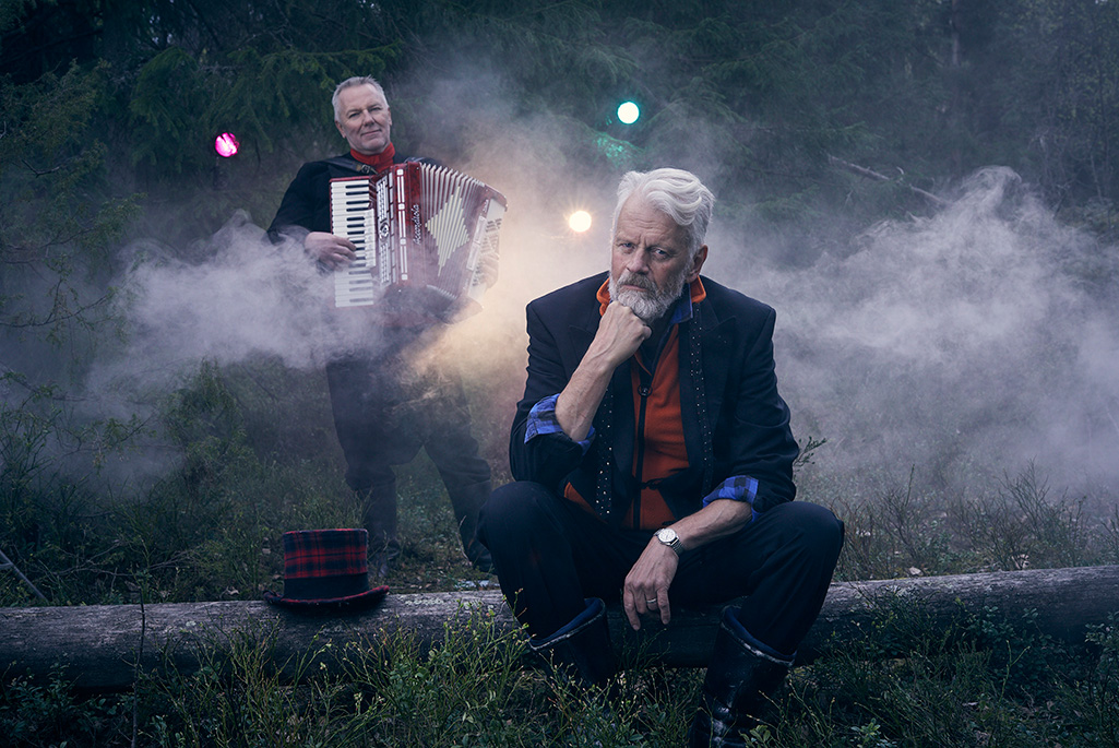 Bild på artisten Ronny Eriksson och en man som står i bakgrunden och spelar dragspel.