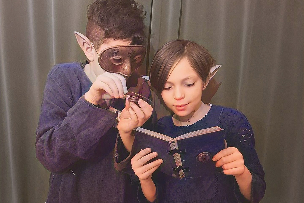 Bild på två barn, en med mask och en med lösöron.