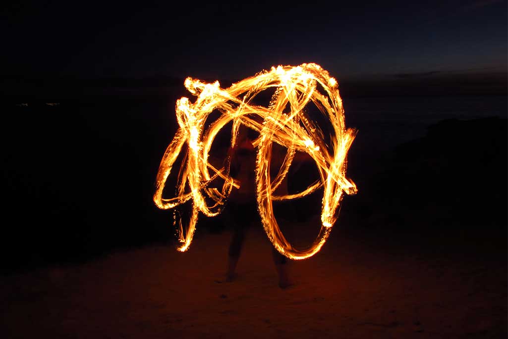 Foto på en gycklare som uppträder och gör en eldshow.