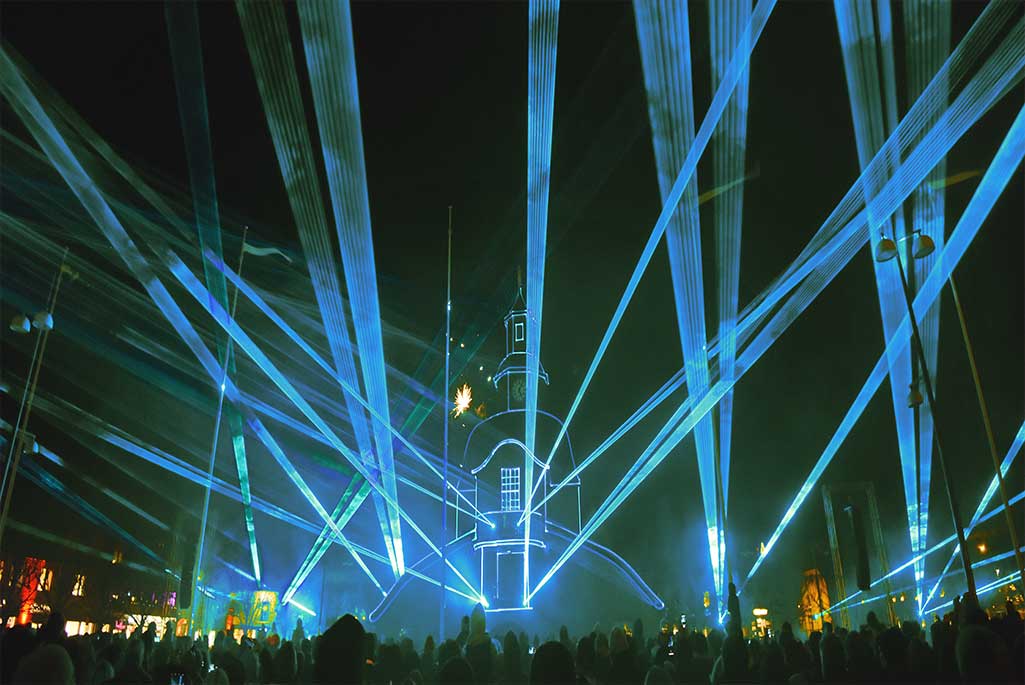 Foto på en lasershow i centrum med en publik.