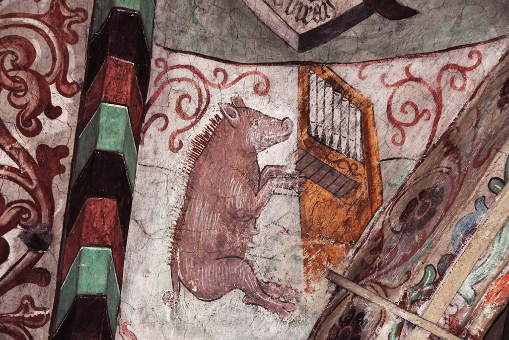 Foto på en målning. Målningen är på en gris som spelar piano.