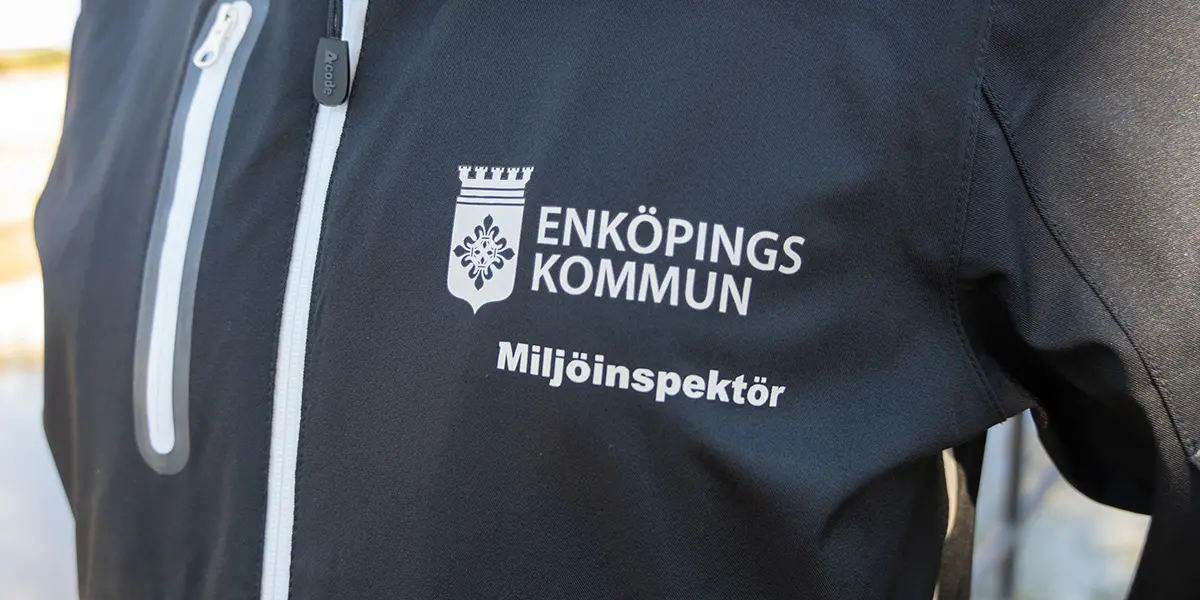 Foto på en jacka med kommunens logga och ordet miljöinspektör på.