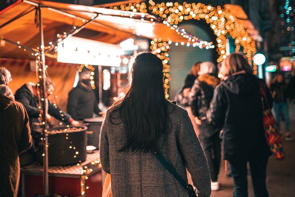 Foto på en tjej som går på en julmarknad.